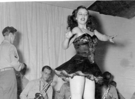 Tap dancer at a USO show in Gushkara, India, during WWII.  The boxes in front of the band players are labeled 748th ROB (748th Railway Operating Battalion).