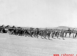 Laborers pull roller at Liuzhou during WWI, in 1945. GI tents can be seen in the distance.