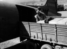 American servicemen load or unload supplies from a US transport plane.  Since, according the stories shared by veterans, African-American servicemen rarely made it into China, this must be outside of China, most likely India or Burma.