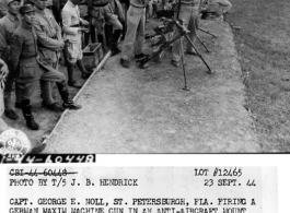 Capt. George E. Noll, St. Petersburgh, FL, firing a German maxim machine gun at an anti-aircraft mount assisted by S/Sgt. Merwin E. Rogers, Willkes-Barre, PA., before a class of Chinese officers in the general staff school, ITC, Kunming, China. 23 September 1944.