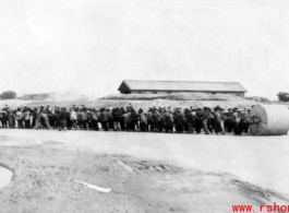 A crew of Chinese civilians pulling a roller at an air base in the CBI. During WWII.