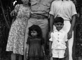 A GI poses with a young family. People in the CBI.