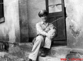 An American serviceman, presumably a member of the  27th Troop Carrier Squadron, sits on a step in the CBI during WWII.