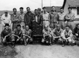 "Communications ground maintenance." Men of the 27th Troop Carrier Squadron surround a large radio unit with tall antenna in the CBI (most likely China).