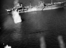 Photo from a B-25 Mitchell running right over a Japanese ship very low during a raid on Hong Kong. Notice bombs in the air on the left, and blurred outline of the plane's twin machine guns in the foreground (presumably this photo is through the tail gunner's window). The separate B-25 that is dropping those bombs is outlined in shadow on the water at the end of the guns.  From a mission on Hong Kong, 491st Bomb Squadron.