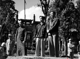 Local men stand on a small bridge in front of walled compound in Yunnan province, China. During WWII.