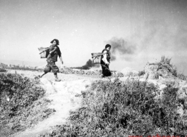 Fleeing women look back over their shoulders at a Japanese air raid on Kunming city in Yunnan province, China, during WWII.