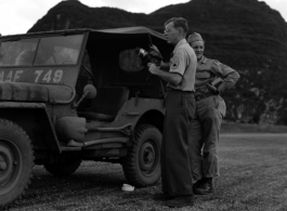 Hal Geer standing near a jeep holding a camera somewhere in Guangxi province, either at Guilin or Liuzhou.