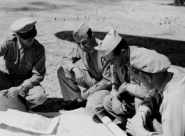 General Chennault on the flight line in conference with pilot officers, navigators, and bombardiers, while a camera crew catches it all in this contrived scene.