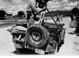 Combat Photographer T/Sgt. Syd Greenberg, 164th Signal Photographic Company, with his Mitchell mobile camera along the Burma Road in 1944. In the CBI in 1944.  Photo by Sgt. Ackerman.