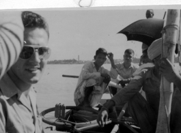 GI crosses Hoogly River in India, during WWII with fellow passengers and a bicycle.