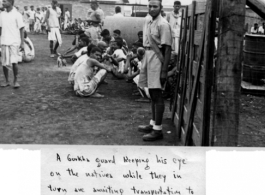 Gurkha guard keeping eye on crowd waiting for transportation to work for the day. In the CBI during WWII.  Photo from Eugene Bernald.