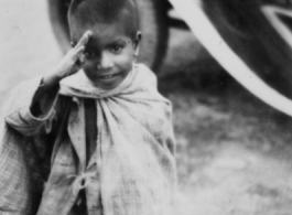 A kid salutes the photographer in the CBI during WWII.