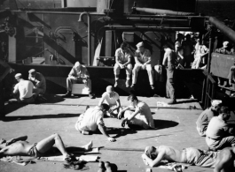 GIs while away the time as they return to the US by ship after war's end, "Relaxing and listening to T. B. S. (tannoy)."  Photo from John Dale Simmons.