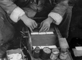 A cigarette roller streetside in China during WWII.