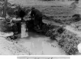 Chinese civilian washing clothes in ditch near Kunming, China, May 1945. Photo by Leipnitz.