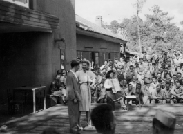 Celebrities (including Ann Sheridan in this shot) perform on an outdoor stage set up at the "Last Resort" at Yangkai, Yunnan province, during WWII. Notice both Americans and Chinese in the audience for this USO event.