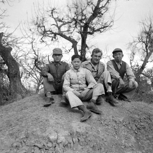 Yunnan (China), three young men employed as housekeepers and launderers sitting with Bert Krawczyk: "These are three houseboys from the airbase at Luliang. Houseboys were provided by the Chinese government under a reverse lend-lease program. The China War Area Service Command administered the program. This command was set up by Madame Chiang Kai-Shek to take care of the food and housing needs of American servicemen in China, who were considered guests by the Chinese government."