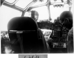 Col. Hopson reading and smoking a cigarette in B-24 cockpit in flight back to US after end of war in the CBI. This is B-24 #44-51040.