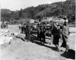 Laborers in a rural location in SW China carry larges timbers. During WWII.