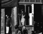 A kid in Guilin, China, climbs through shop window. During WWII.