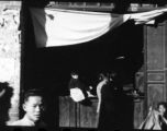 People at the door of a small retail shop in China during WWII.