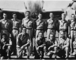 Men from the 21st Photographic Reconnaissance Squadron pose for a group shot in front of an F-5 (a variant of the P-38).