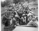 7th Veterinary Company GIs packet tightly into train cars for transport. A Red Cross "Clubmobile" truck is parked on a road in the background. During WWII in the CBI.