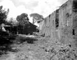 Adobe back wall of a large building. Local scenes and local people in Yunnan province, China, most likely around the Luliang air base area.