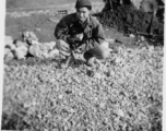 Probably a local boy in China, holding a small animal. During WWII.