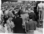 Burma Road dedication parade and ceremony in Kunming, China, on or around February 4, 1945, during WWII. Review of first convoy (or one of the first convoys) to reach China. Ranks of soldiers and civilians. Note movie camera filming on top.