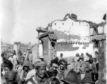 Local people walk by devastated buildings in Yunnan, during WWII.