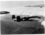 B-25s of the 22nd Bombardment Squadron in flight over rough mountains of SW China or Burma during WWII.