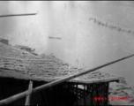 Houses clustered on the Yellow River during WWII, possibly in or near Lanzhou, and a boat in the river.