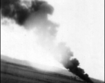 An American airplane burning in the distance after a Japanese air raid. In China, during WWII.