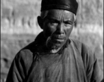 An elderly man poses for the photographer in China during WWII.