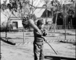 A young candied fruit seller selling candied haws fruit on bamboo skewers during WWII.