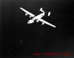 B-24 bomber in flight, CBI.  Note the shark nose art.  During WWII.