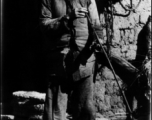 A man on the street in China, smoking a very long pipe, maybe Liuzhou or Yangkai.