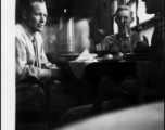 Everett Lull, Paul Hunt, and James Vaughn relaxing over a few drinks and food in the CBI, most likely on or near an American air base in China, during WWII.