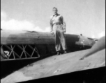 Paul Hunt standing of the wing of a damaged transport plane in the CBI.