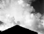 A village near Yangkai, Yunnan province, China: Bright clouds high in the sky. During WWII.