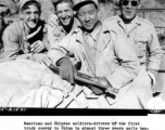 American and Chinese soldiers--drivers of the first truck convoy to China in almost three years smile happily as they reach the China border at Wanting.  The dusty, begrimed drivers took turns with their Allies in driving over the 1,004-mile route form Ledo, India, to Kunming, China. During WWII.   (OWI-PW staff photo by Sgt. John Gutman)