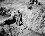 Scenes around Kunming city, Yunnan province, China, during WWII: A Chinese conscript works mud, probably for adobe brick or fired brick making. 
