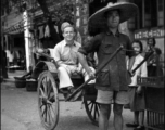 Scenes around Kunming city, Yunnan province, China, during WWII: Rickshaw puller and GI pose for a picture.