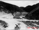 A simple vehicle passes along a newly cut road in SW China during WWII.