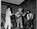 Costumed men perform music, while the "Jive-o-Lieps" of the 54th Air Service Group wait their turn In the CBI during WWII.