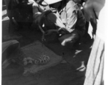 A GI negotiates for metal jewelry in India.  Scenes in India witnessed by American GIs during WWII. For many Americans of that era, with their limited experience traveling, the everyday sights and sounds overseas were new, intriguing, and photo worthy.
